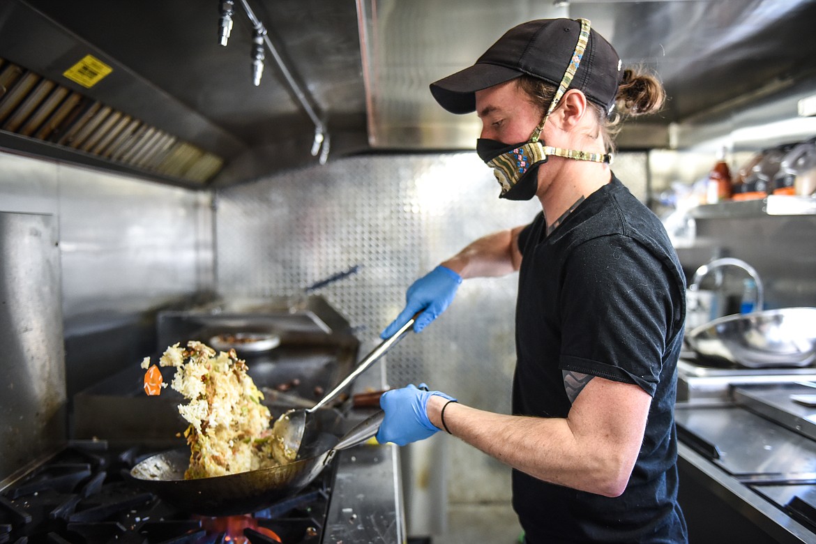 Connor Kelly cooks up ingredients for a fried rice bowl inside the Sasquatch Grill food truck in Columbia Falls on Wednesday. (Casey Kreider/Daily Inter Lake)