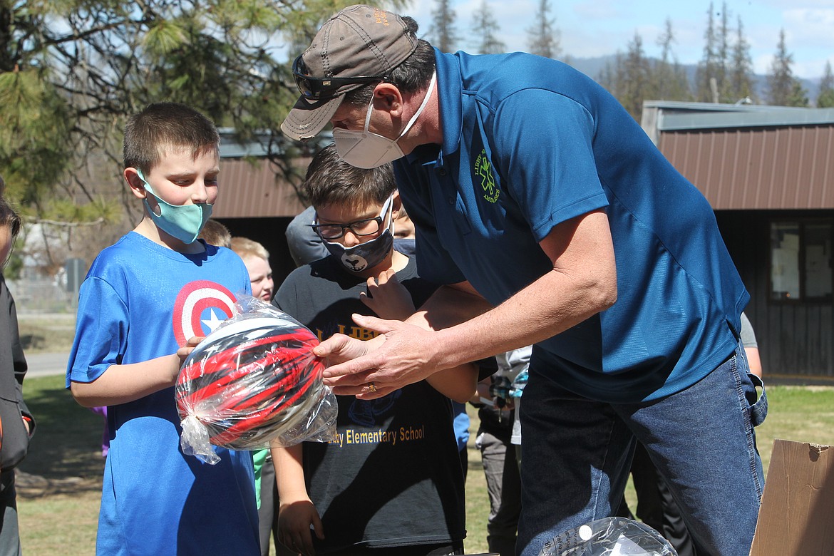 Jeff Holder, of Libby Volunteer Ambulance, presents third graders at the Libby Elementary School with bike helmets on April 20. (Will Langhorne/The Western News)