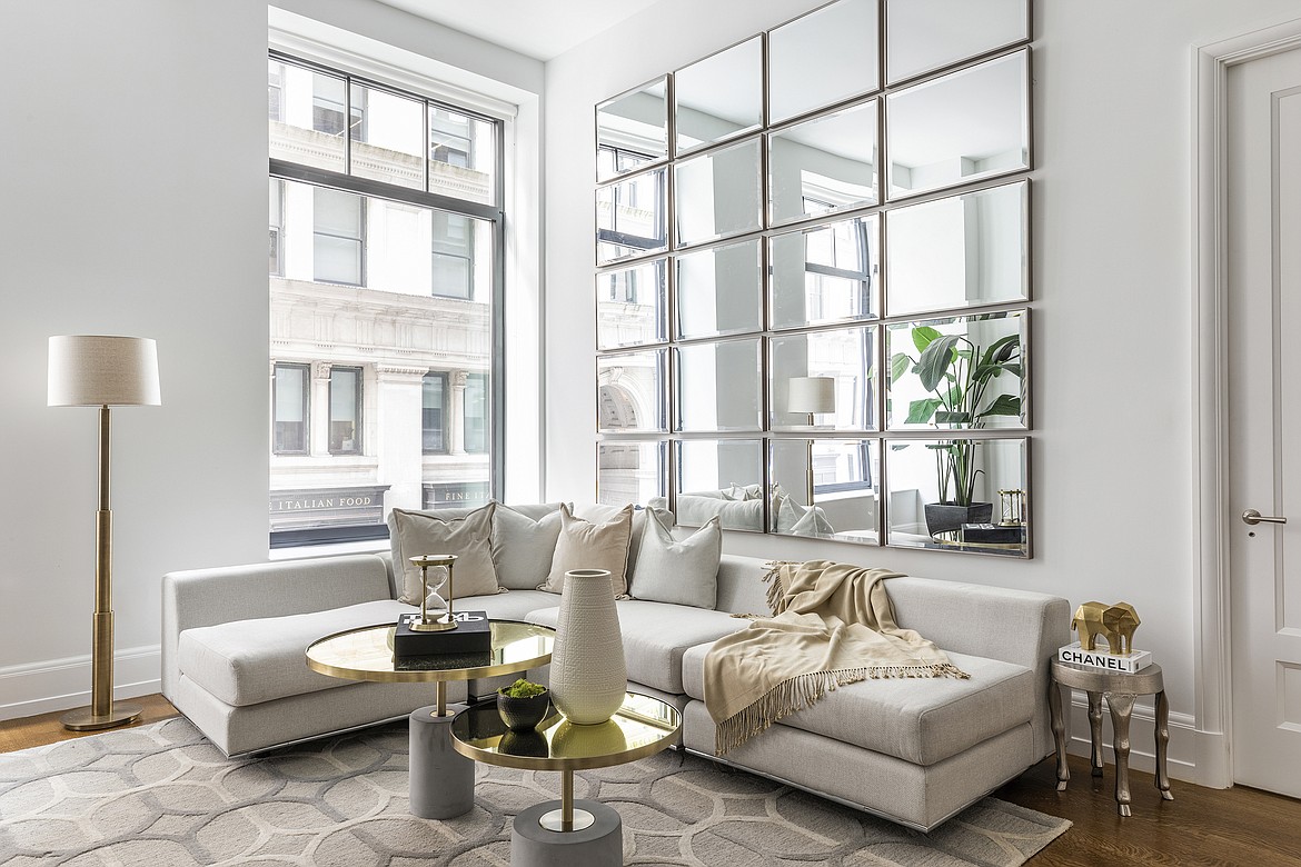 A low back sofa placed in a corner below a windowsill helps make a small living room feel larger.