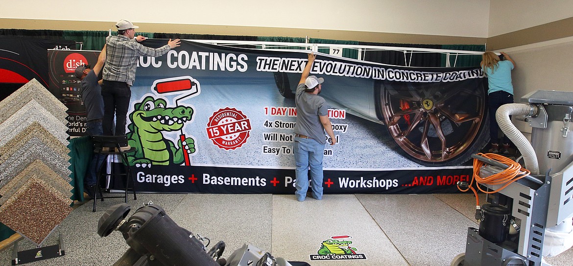 The crew with Croc Coatings sets up displays for the Home & Garden Show at the Kootenai County Fairgrounds on Thursday.