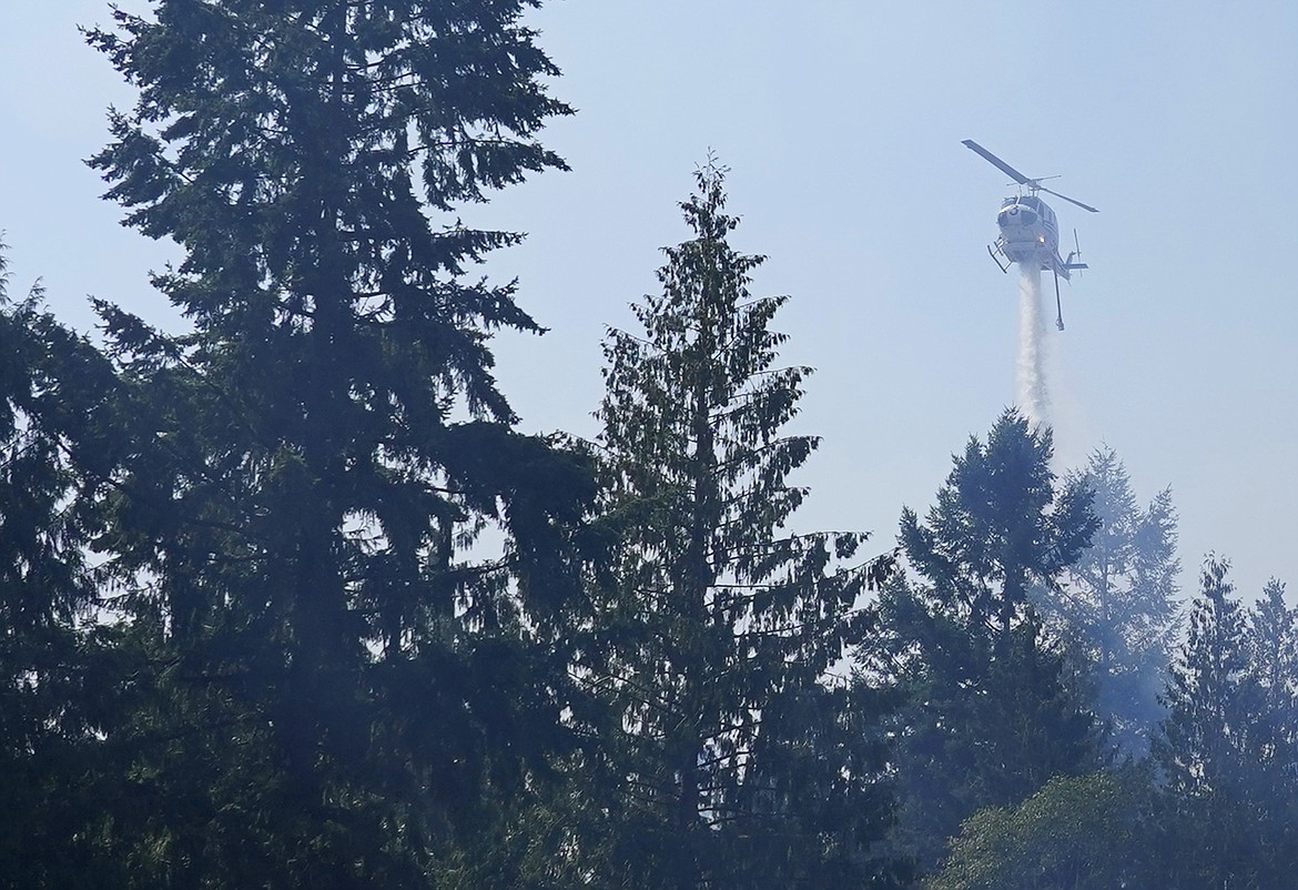 In this Sept. 9, 2020, file photo, a helicopter makes a water drop on a hotspot of a wildfire burning in Bonney Lake, Wash., south of Seattle. A bill to spend $125 million to prevent and fight wildfires in Washington state was passed by the House on Thursday, April 22, 2021, and now will go to Gov. Jay Inslee for his signature.