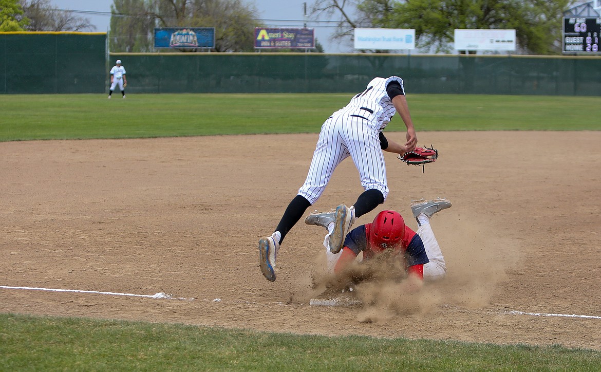 Moses Lake High School third baseman Leo Cortez flies into the air as he collides with the runner while trying to secure an errant throw on Saturday against Brewster High School.