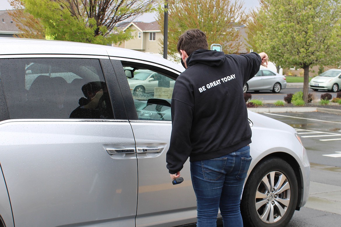 Boys & Girls Club volunteer Sky Palsted directs traffic at the Spaceburger Fest on Saturday.