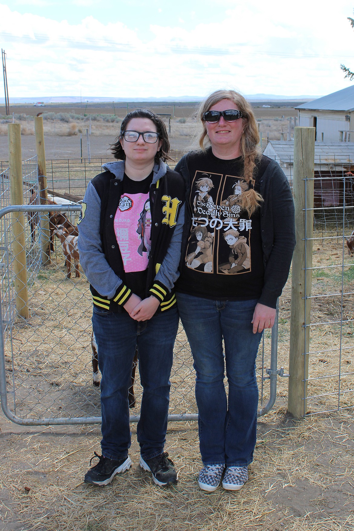 Kaitlin Baum (left) and her mom, Megan Baum (right) pose before their Boer goats at the barter faire on Sunday.