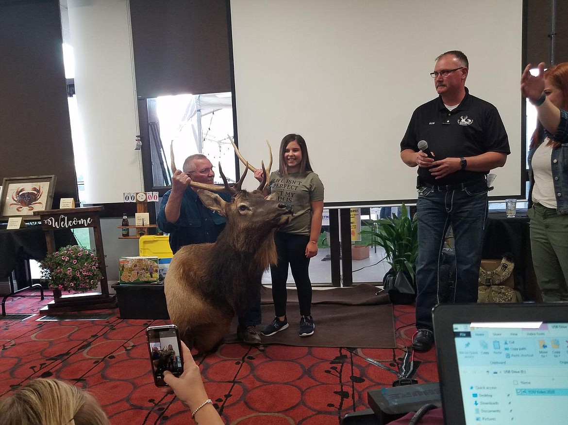 Ten-year-old Avery Reyes receives her elk mount from a Youth Outdoors Unlimited hunt last fall at Saturday's auction.