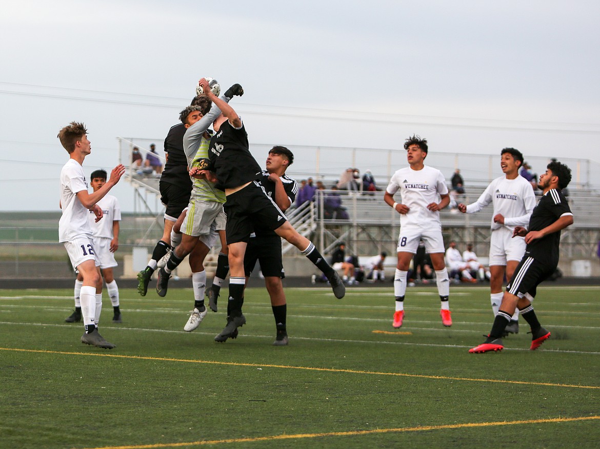 A pair of Royal High School players collide with the Wenatchee goalkeeper in the second half as the trio go up for a ball on Friday night at Royal High School.