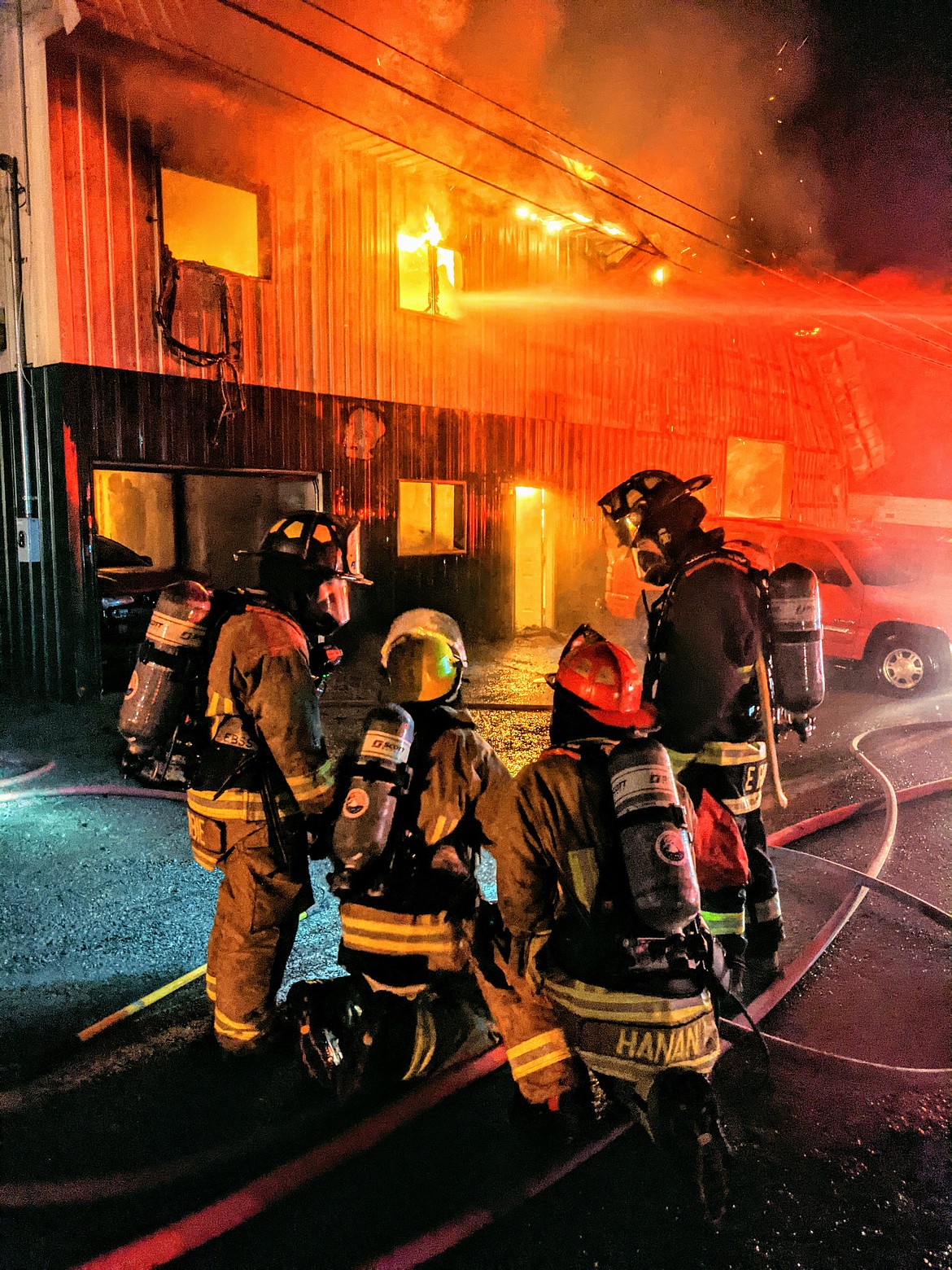 Shoshone County Fire District No. 1 and 2 firefighters game plan before getting closer to the fire Thursday night.