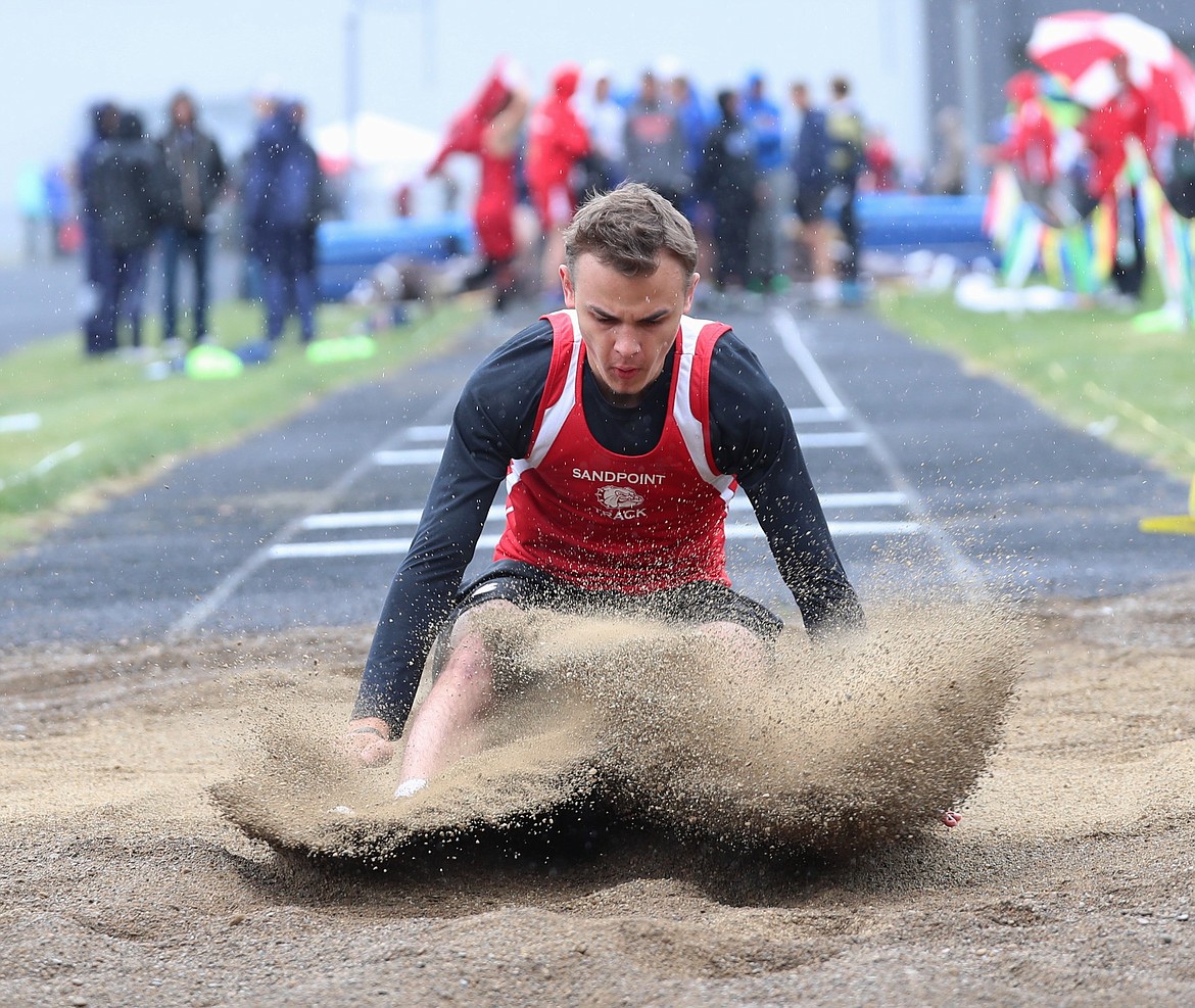 Zac Whittom splashes into the pit in the long jump on Saturday.