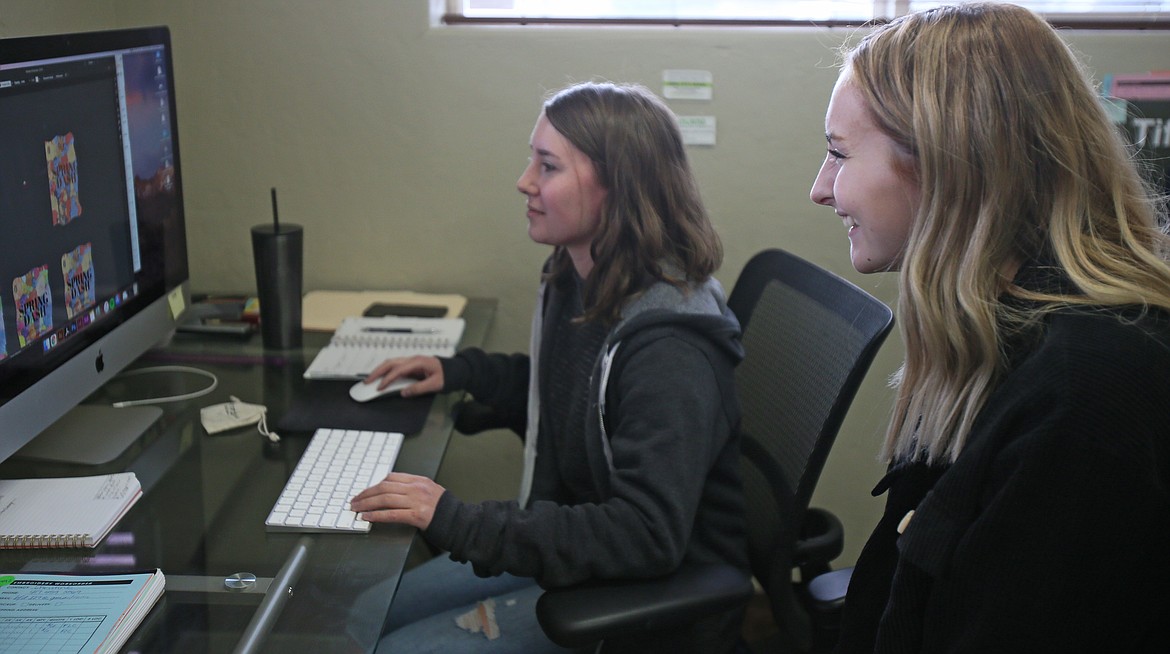 Graphic designer Tatum Hartley, left, shows Spring Dash T-Shirt Design Contest winner Maysen Deming a few steps in the process of putting her design on T-shirts during a visit to StandOut Promotion in Hayden on Monday.