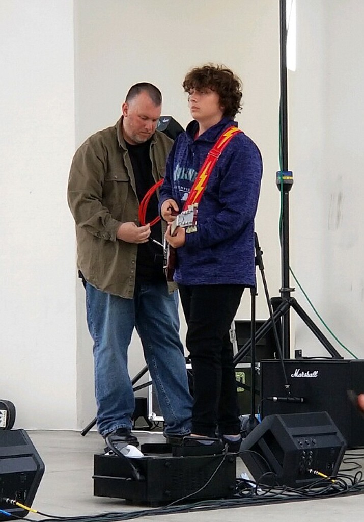 Steve Rimple helps "roadie" for his son Gunnar Rimple before he performs the National Anthem at Spring Fest in 2019.