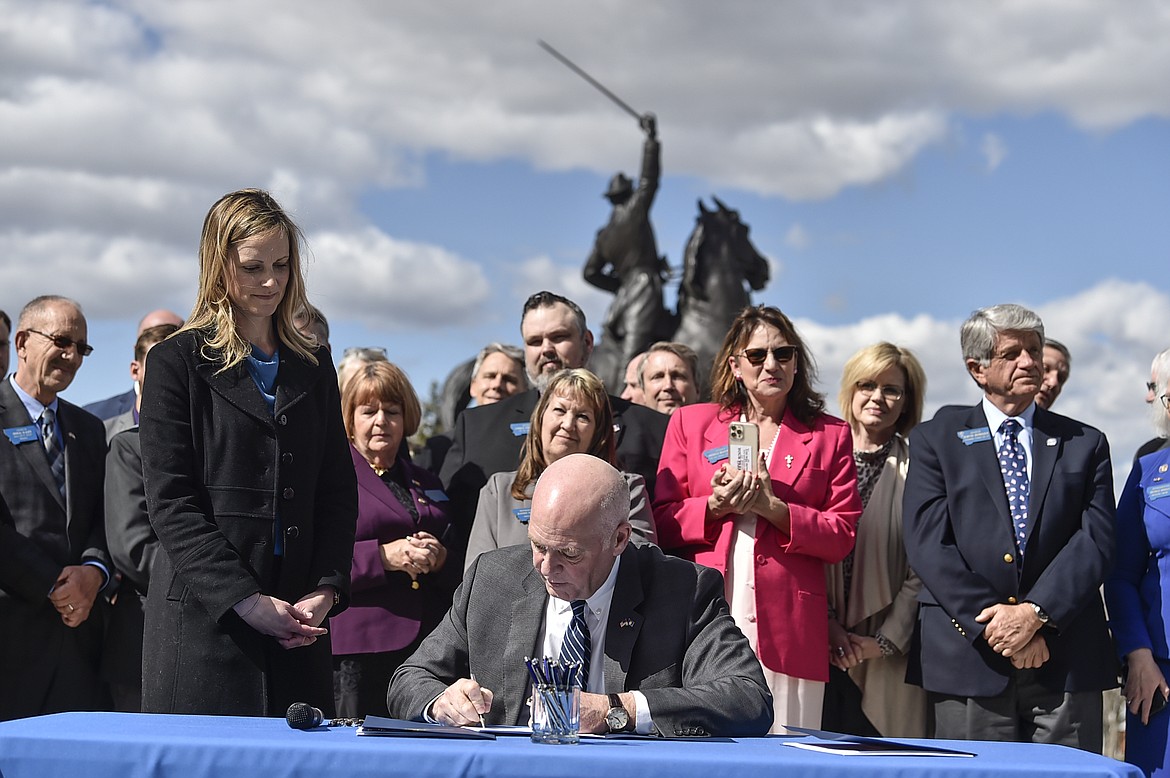 In this April 26, 2021, file photo, Republican Gov. Greg Gianforte signs a bill from Rep. Amy Regier, R-Kalispell, requiring that women be informed of the opportunity to view an ultrasound before an abortion. (Thom Bridge/Independent Record via AP)