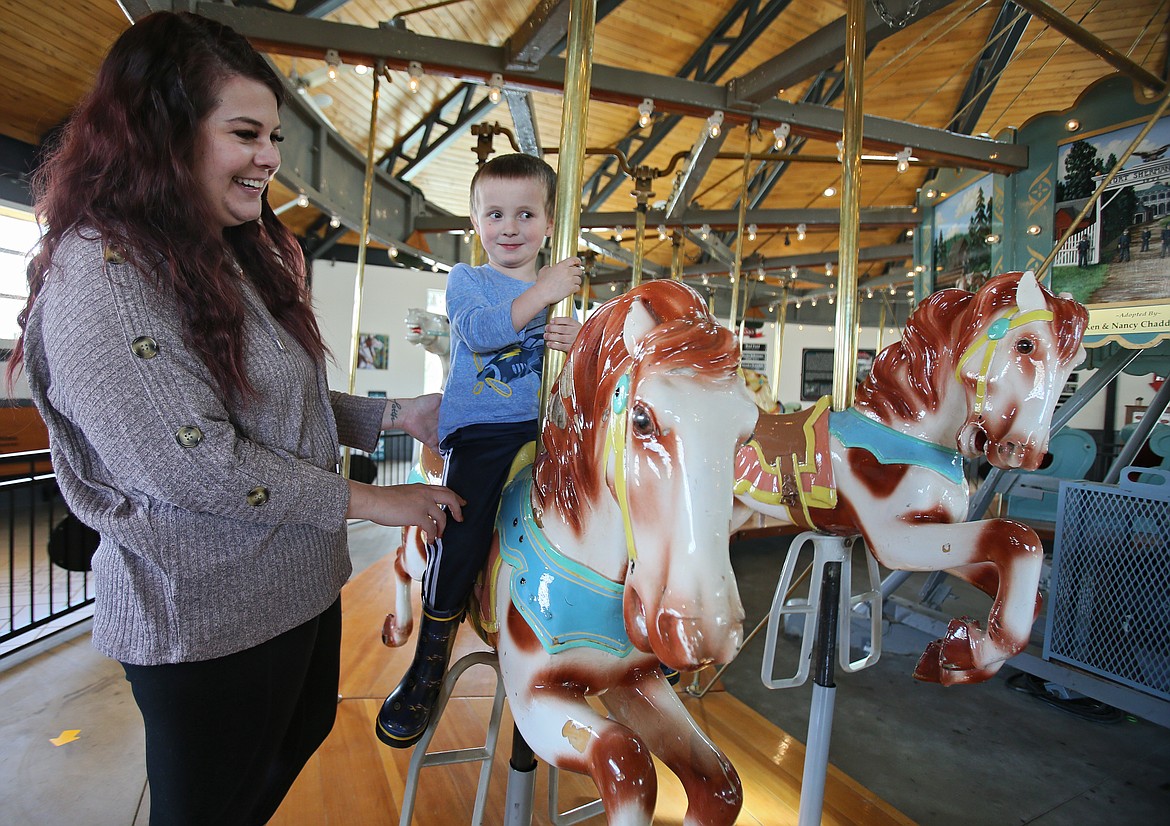 Paige McCan accompanies her 4-year-old son Logan McCan at the Coeur d'Alene Carousel on Friday as he selects pony No. 12 to be named "Starfire" for the 2021 season. The carousel opens for the season on Saturday.