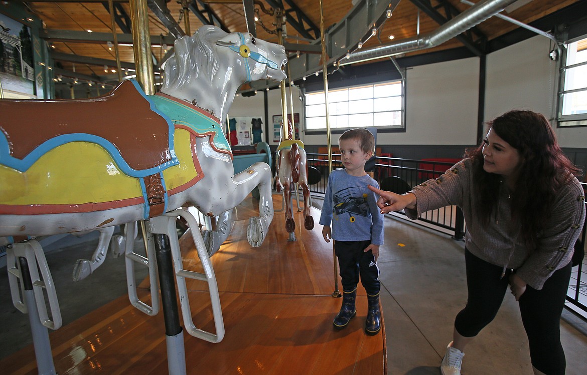 Logan and mom Paige McCan inspect which pony to name "Starfire" during a visit to the Coeur d'Alene Carousel on Friday. The carousel opens for the season on Saturday. Volunteers are needed and new pony naming opportunities are being offered.