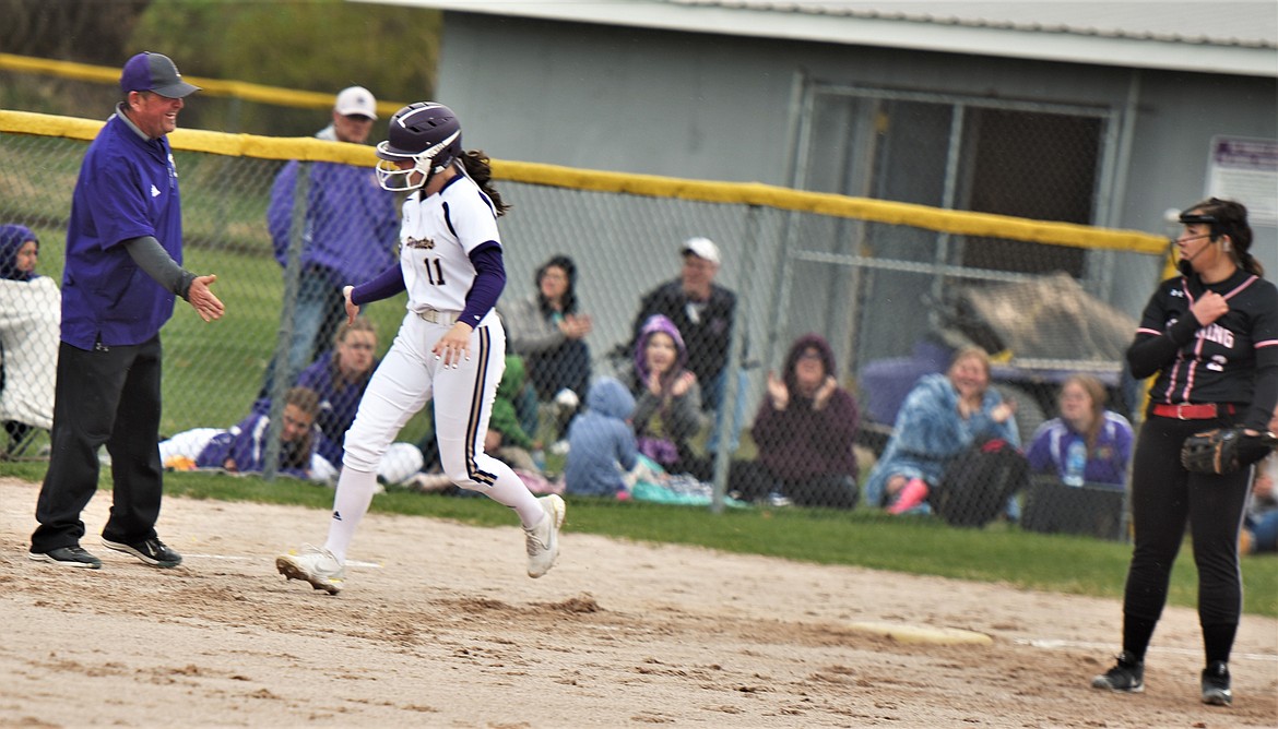 Lexy Orien greets head coach Jami Hanson at third base after hitting a two-run home run against Browning. (Scot Heisel/Lake County Leader)