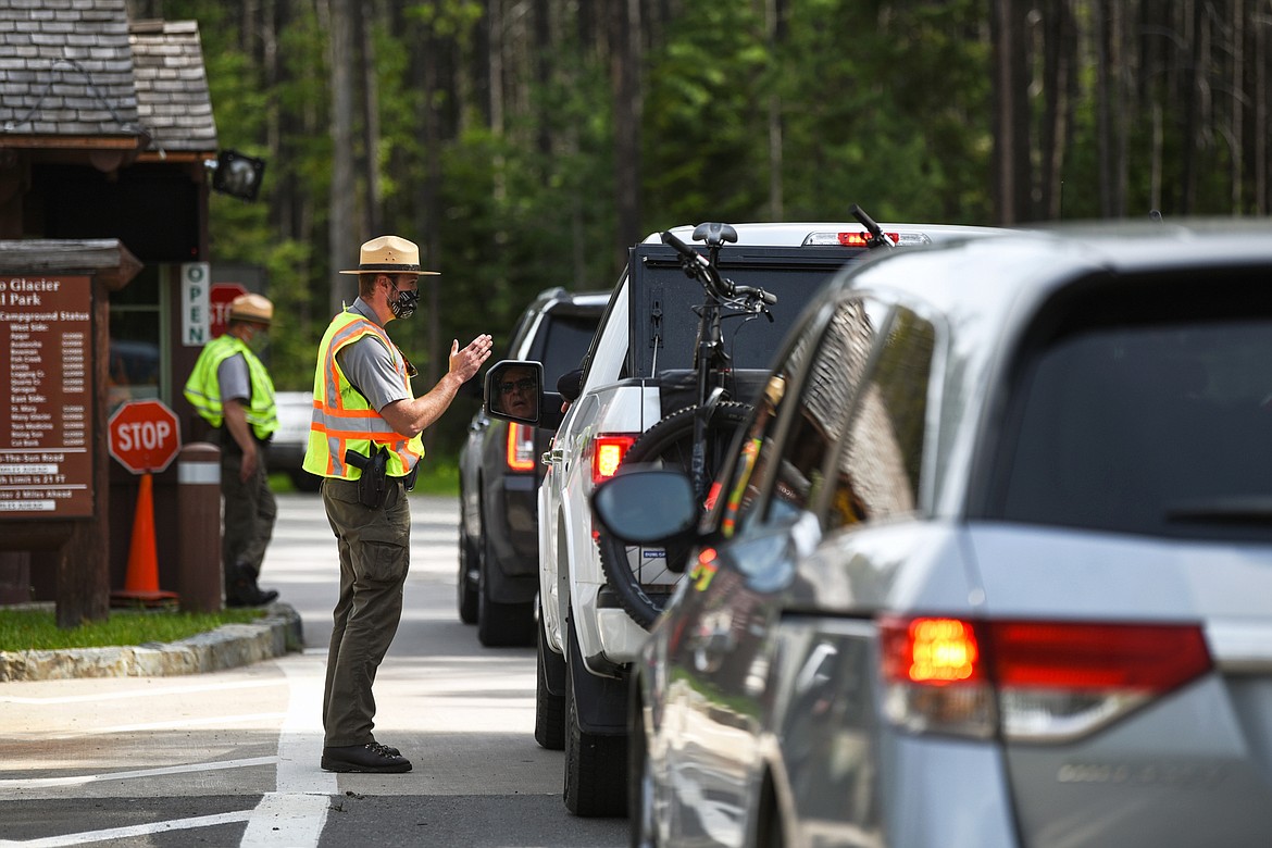 Park rangers speak to visitors at the West Glacier entrance to Glacier National Park on Friday, June 12, 2020. (Casey Kreider/Daily Inter Lake)