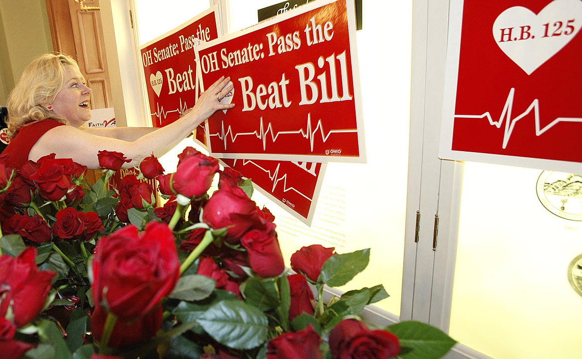 In this Feb. 14, 2012, file photo, Janet Folger Porter, president and founder of Faith 2 Action, posts signs during a news conference at the Ohio Statehouse in Columbus, Ohio. Bans pegged to the “fetal heartbeat” concept have been signed into law in 12 states, but all have either been struck down or temporarily blocked by the courts and none has taken effect. Porter urged supporters to “take heart” when faced with obstacles — and beseeched lawmakers to “have a heart” and vote “yes" despite their constitutional concerns.