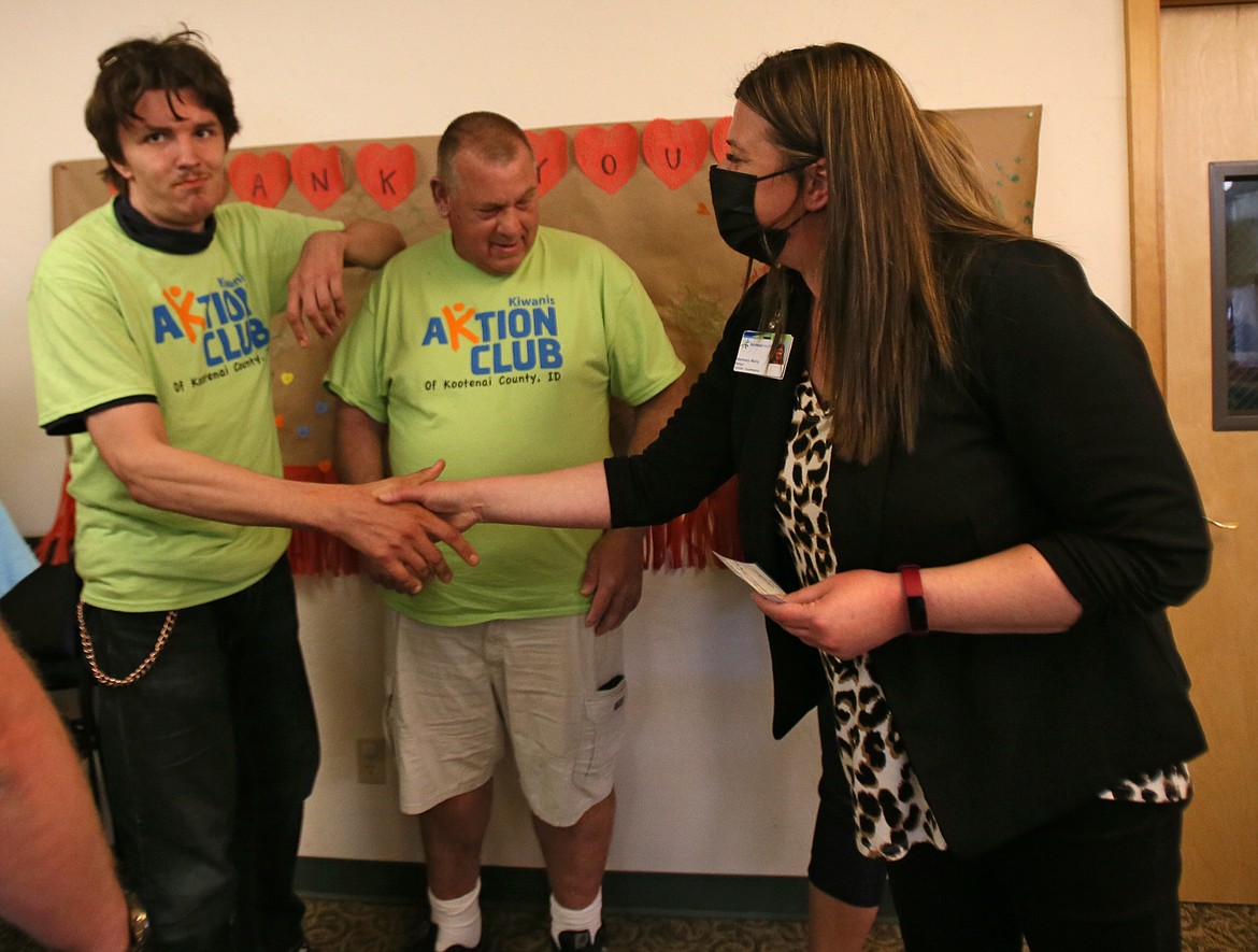 Kootenai Health facilities/housekeeping manager Harmony Reilly on Wednesday shakes Aktion Club Chairman Robert McRae's hand while thanking him and President Matt Jenkins for their club collecting nearly $200 to cover coffee and food for hospital housekeeping staff.