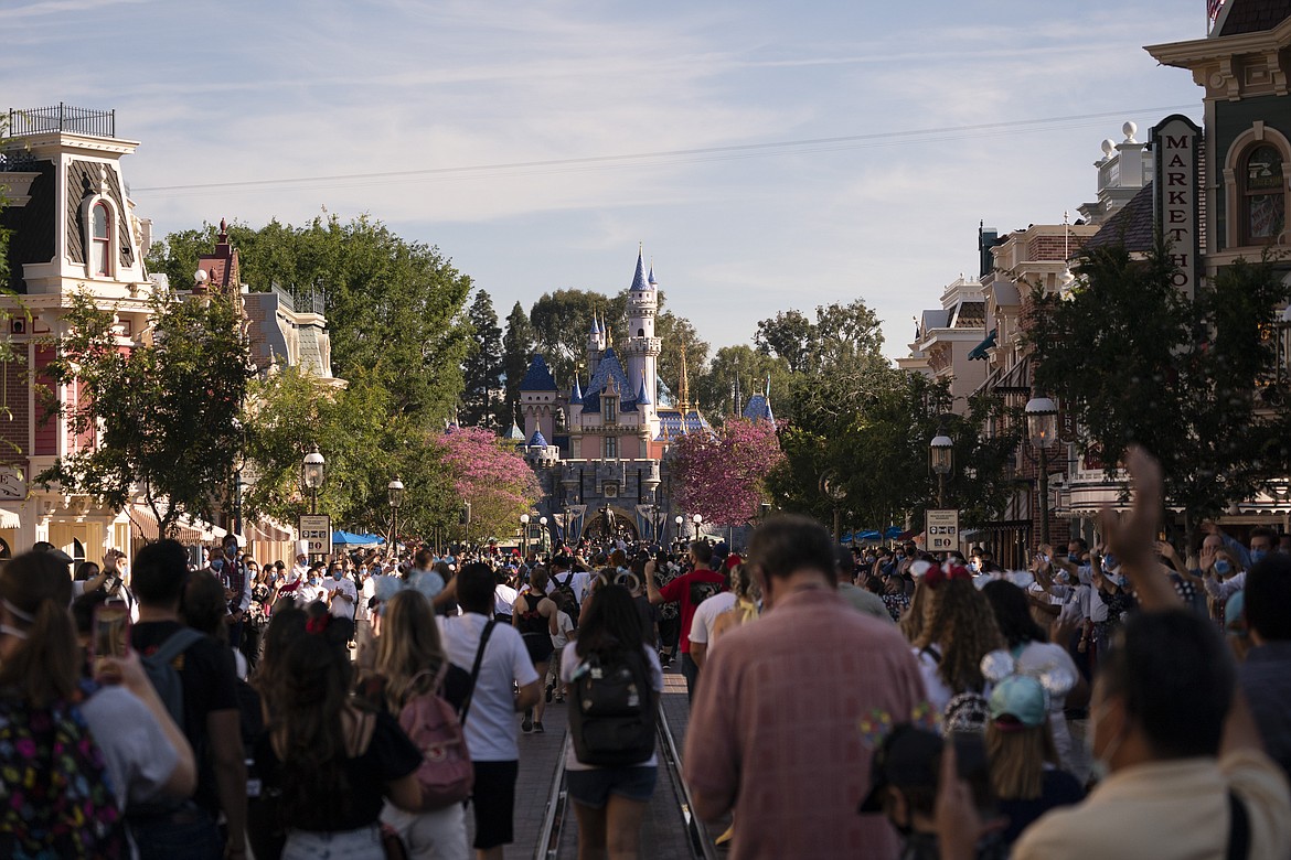 Guests walk along the Main Street USA at Disneyland in Anaheim, Calif., Friday, April 30, 2021. The iconic theme park in Southern California that was closed under the state's strict virus rules swung open its gates Friday and some visitors came in cheering and screaming with happiness.