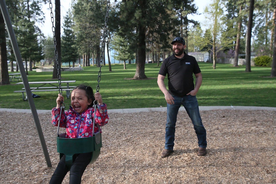 Single dad Josh Walker gives his adopted little girl Aaliyah, 3, a reason to giggle as he pushes her in a swing in a Post Falls park on Tuesday.
