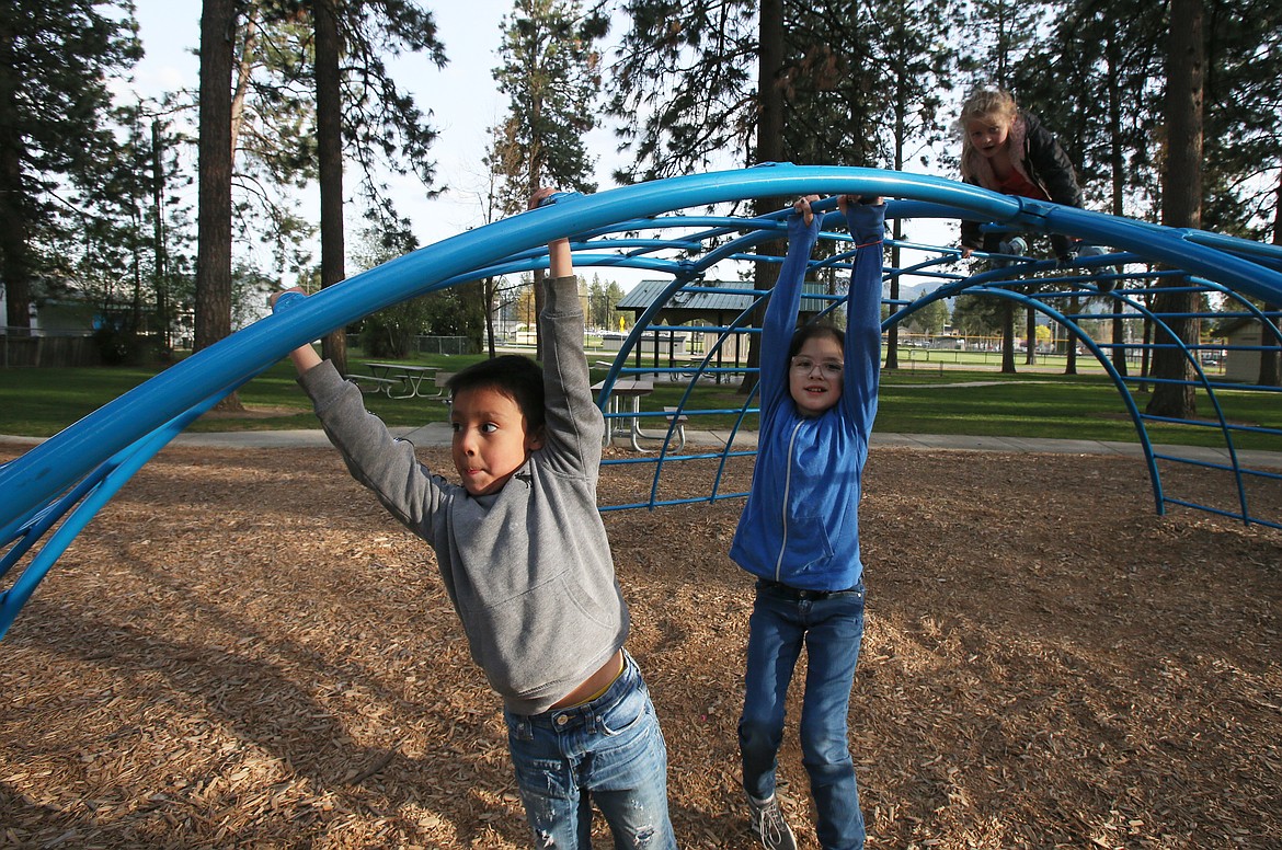 Jeremiah, 7, and Dakota Walker, 10, play in a Post Falls park on Tuesday. The kiddos are part of a large family that received a new washer, dryer and deep freezer from Press Christmas for All.