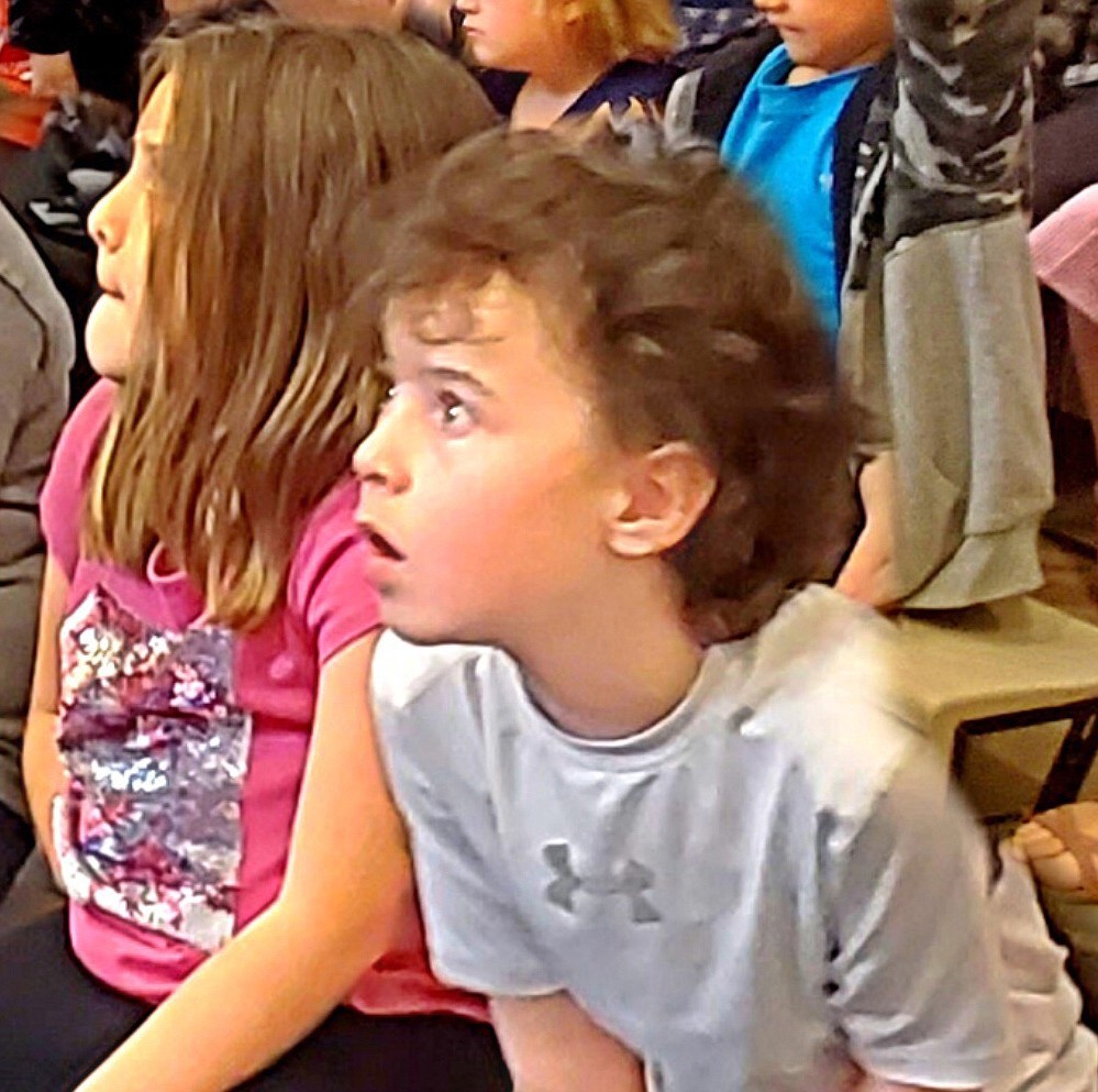 First-graders Brooklyn Score and Emmitt Massey get excited for literacy during a Jazzed about Reading assembly at Twin Lakes Elementary on Thursday. Jazzed about Reading will present to more Lakeland schools this month to encourage students and reward them for reading.