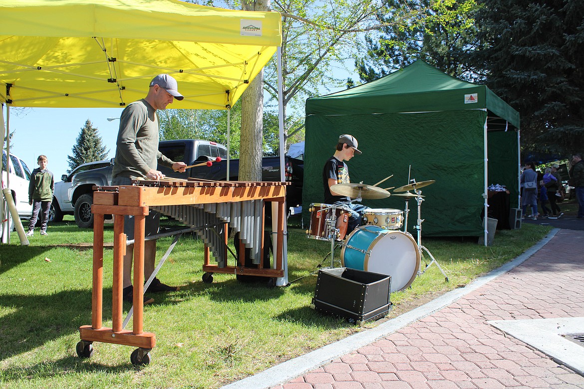 Big Bend Community College Professor Dr. John Owens, left, performs a percussion set with his son, Milton, at the Moses Lake Farmers Market on Saturday.