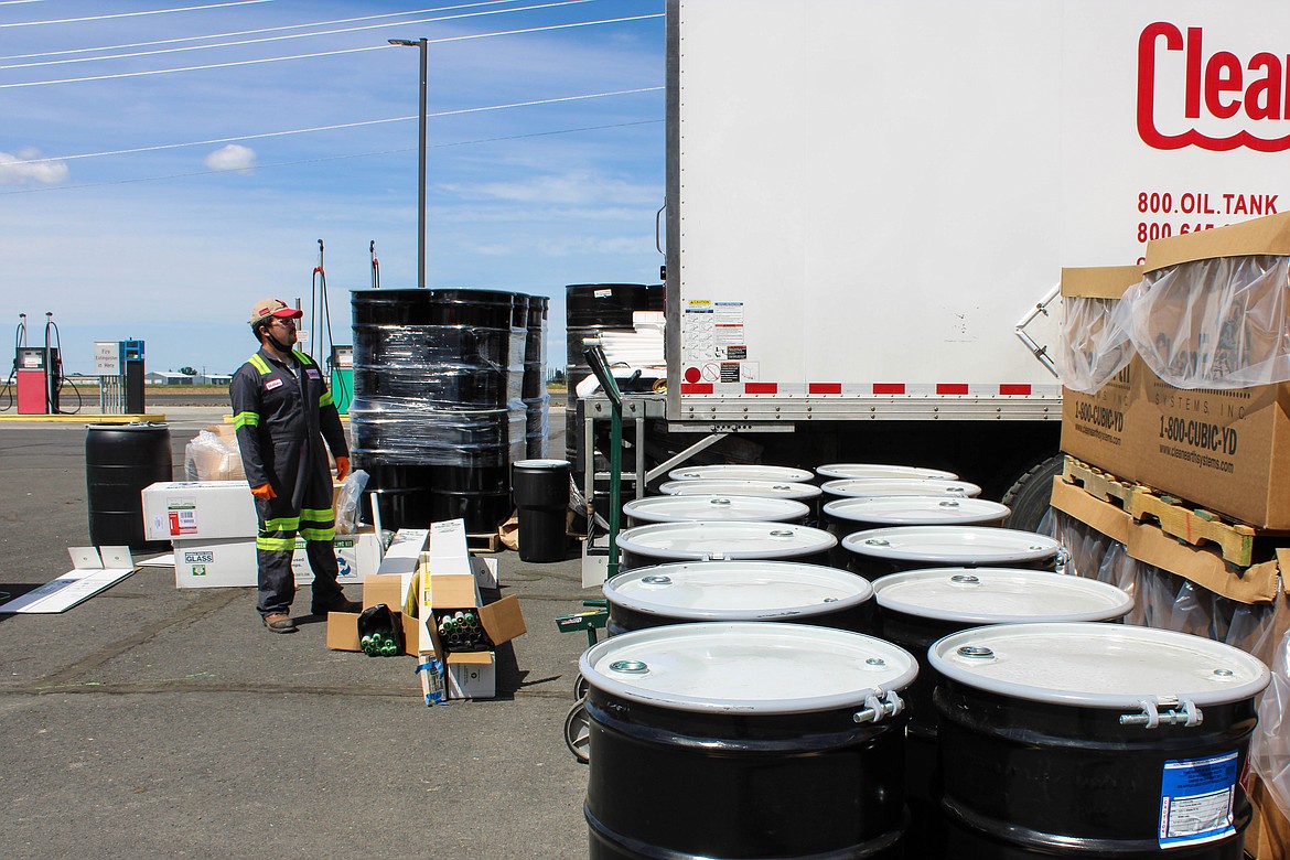 Public Works staff Jacob Beck loads hazardous material drums into a truck at the Household Hazardous Waste event on Saturday.