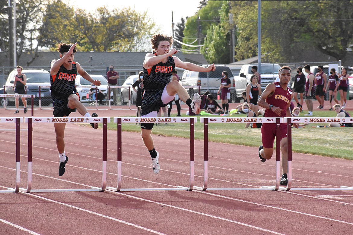 Left to right, Ephrata's Josue Sanchez and Travis Hendrick and Moses Lake's Solmon Green make their way over a set of hurdles at the track & field meet at Moses Lake High School last Thursday.