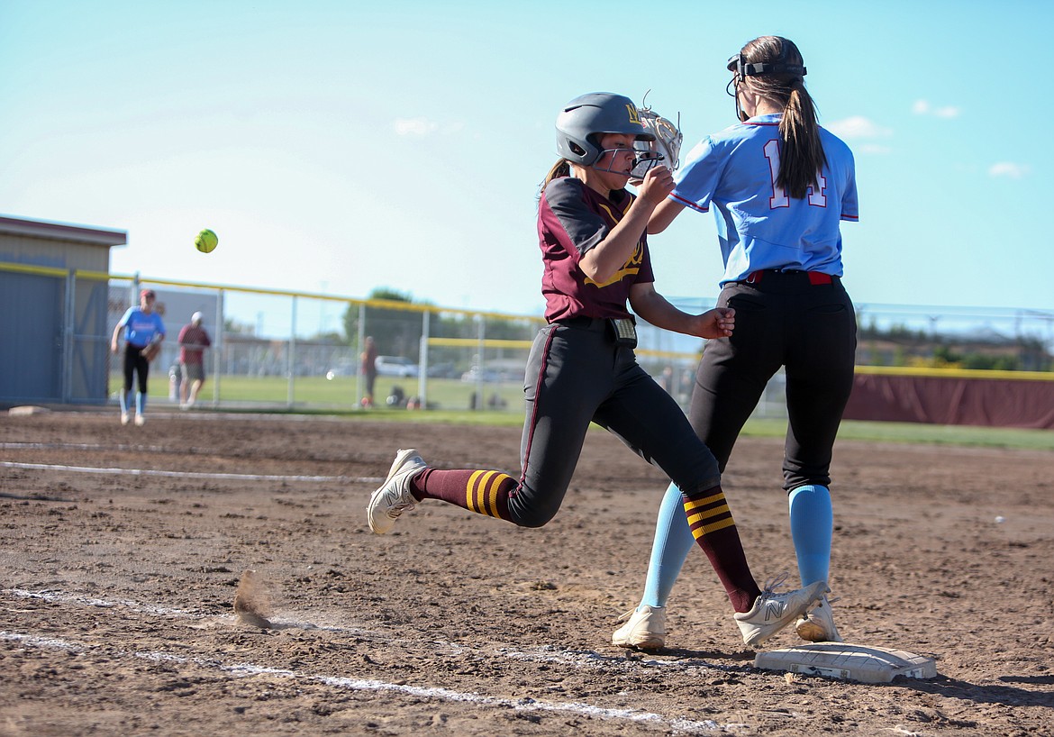 Raegan Hofheins beats the errant throw to first base on her way to a home run off a bunt in the sixth inning for Moses Lake High School at home on Tuesday afternoon.