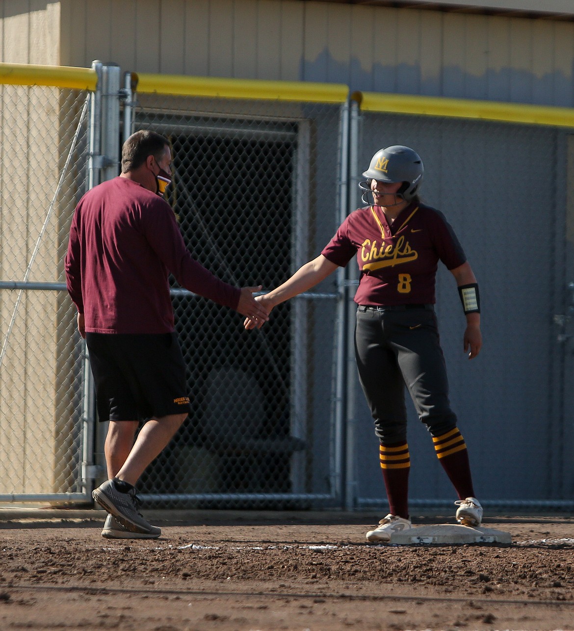 Taylor Hofheins and her dad, Moses Lake head coach Mike Hofheins, celebrate at third base after the senior drove in multiple runs on a triple on Tuesday afternoon.