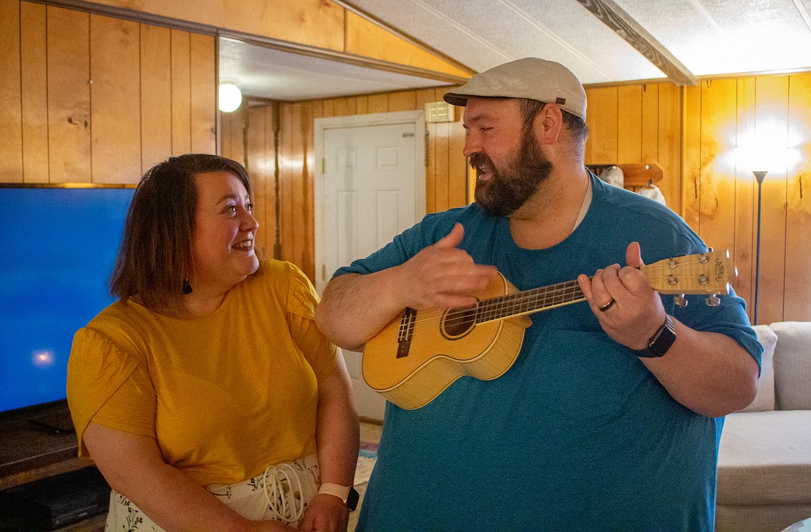 Emily Duvall smiles watching her husband Michael Duvall play her a tune on his ukulele in their living room outside of Moses Lake on Monday evening.