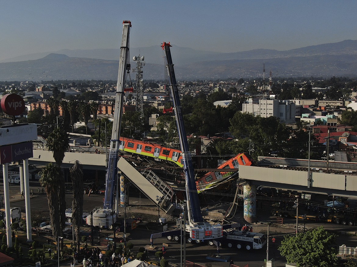 Subway cars dangle at an angle from a collapsed elevated section of the metro, in Mexico City, Tuesday, May 4, 2021. The elevated section of the metro's Line 12 collapsed late Monday killing at least 23 people and injuring at least 79, city officials said.