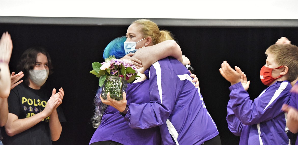 Program coordinator Kris Kelly, left, hugs fellow coach Melesa Butler during the award presentation last week at Polson High School. At far left, Draven Mastel claps, as does Tristan Butler at far right. (Scot Heisel/Lake County Leader)