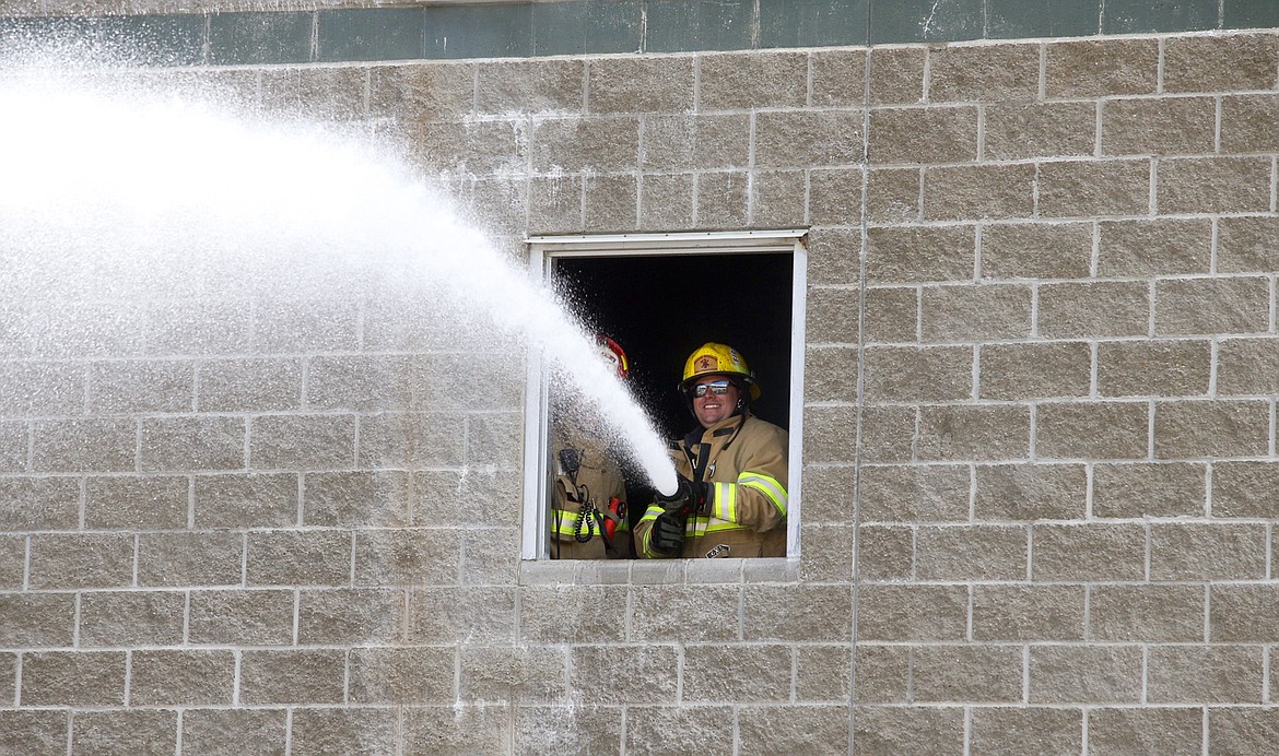 Jared Reed, KCFR emergency vehicle technician, handles a high-pressure fire hose during Tuesday's training day for non-response staff.