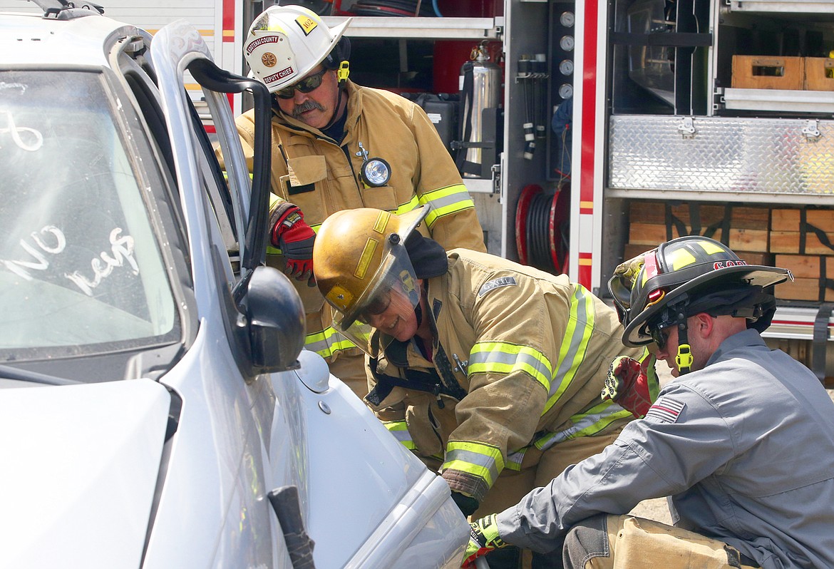 Laurie  Perkinson, KCFR accounting clerk, uses the jaws of life under the watchful eyes of Capt. Adam Godwin and Chief Dan Ryan during a training day on Tuesday.