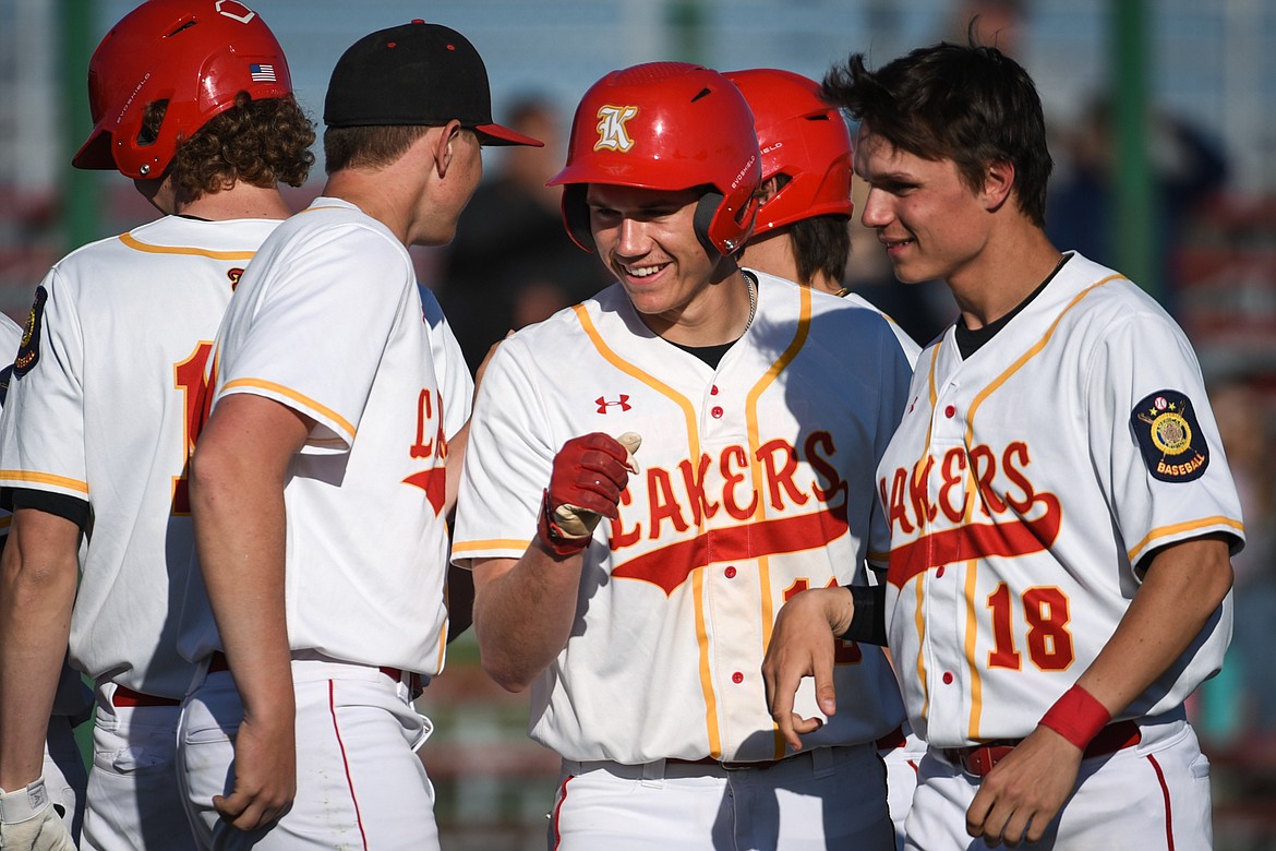 Kalispell Lakers AA's Ethan Diede (13) gets congratulated after scoring a run against the Libby Loggers A at Griffin Field on Wednesday. (Casey Kreider/Daily Inter Lake)