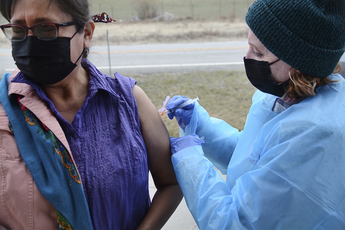 In this Thursday, April 29, 2021, photo, Sherry Cross Child, a Canadian resident of Stand Off, Alberta, receives a COVID-19 vaccine at the Piegan-Carway border crossing near Babb, Mont. The Blackfeet tribe in northern Montana gave out surplus vaccines in April to its First Nations relatives and others from across the border. (AP Photo/Iris Samuels)