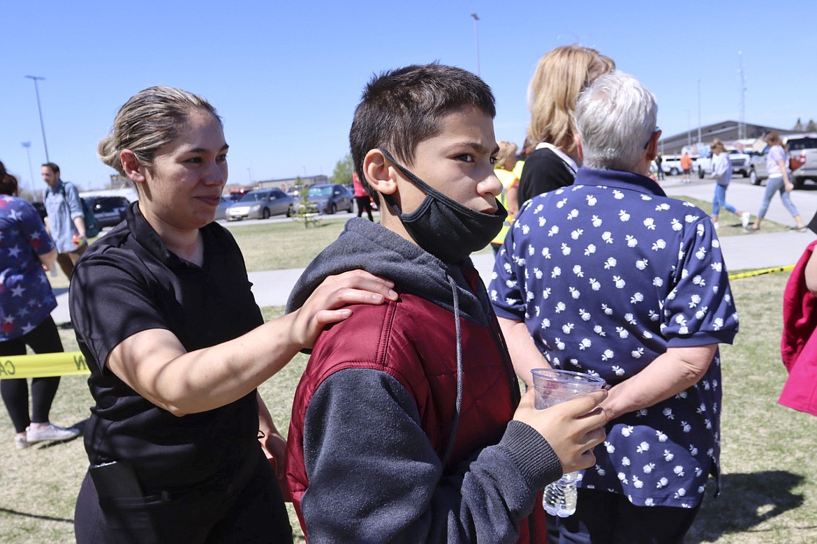 Adela Rodriguez, left, walks with her son, Yandel Rodriguez, 12, at the high school where people were evacuated after a shooting at the nearby Rigby Middle School earlier Thursday, May 6, 2021, in Rigby, Idaho. Authorities said that two students and a custodian were injured, and a male student has been taken into custody.