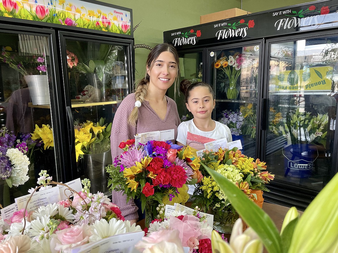 Rosa Guerrero, manager of Florist in the Garden in downtown Moses Lake, and her daughter (and helper) Melody Madrigales, 7, behind bunches of flowers being given as gifts for Mother’s Day.