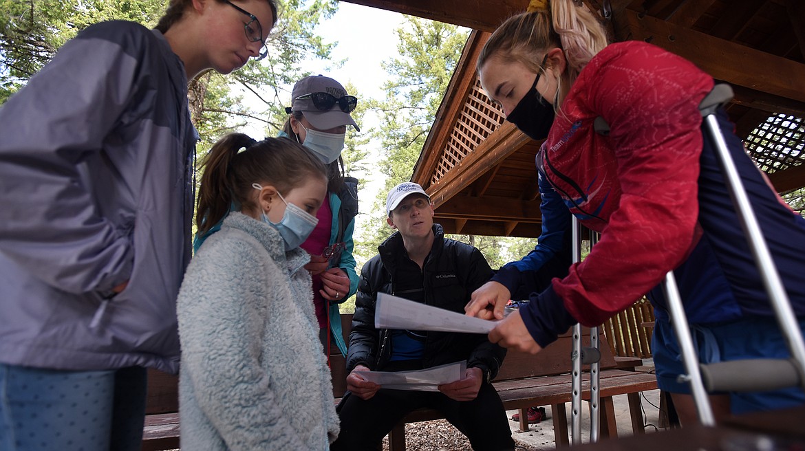 The Nelson family, Lily (13), Evelyn (8), Maggie and Jesse get tips from Team USA member Siri Christopherson before taking on Grizzly Orienteering's course at Lone Pine State Park Sunday. (Jeremy Weber/Daily Inter Lake)