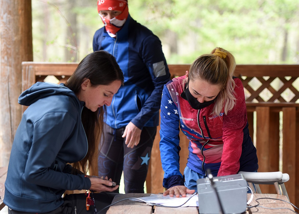 Sara Bednarcik consults with Team USA member Siri Christopherson before taking on the orienteering course at Lone Pine State Park Sunday. (Jeremy Weber/Daily Inter Lake)