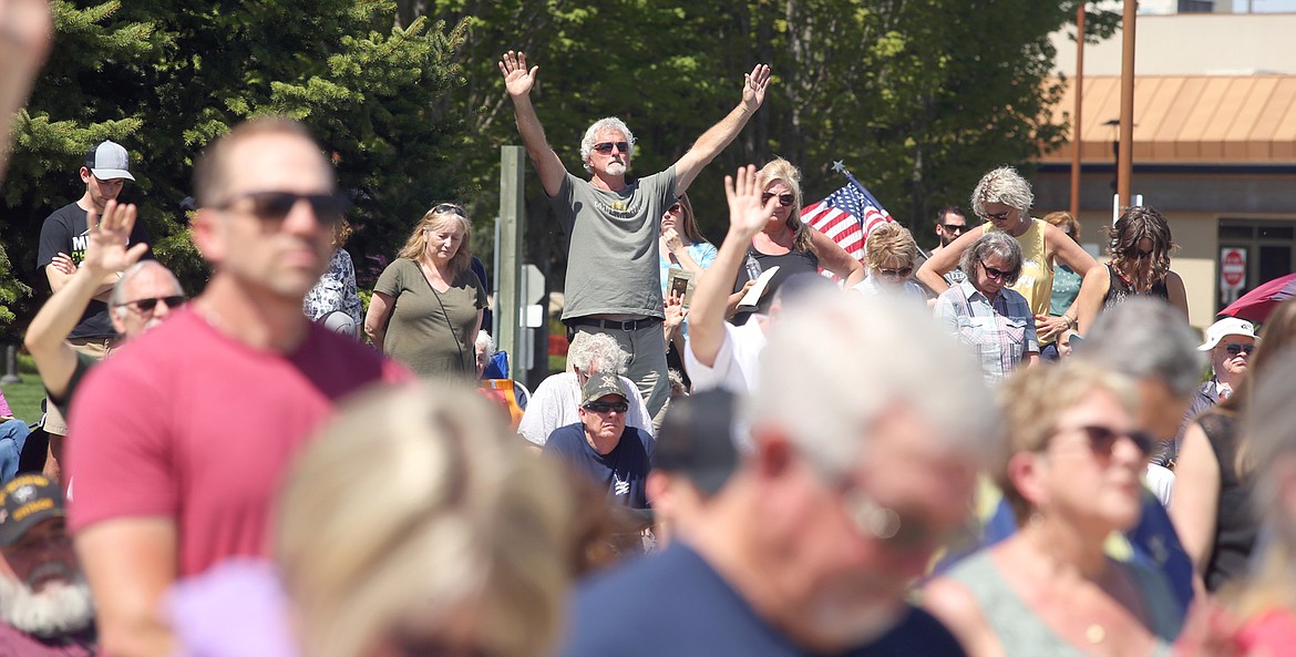 Roger Roosendaal raises his arms during his prayers at the National Day of Prayer gathering in Coeur d'Alene on Thursday.