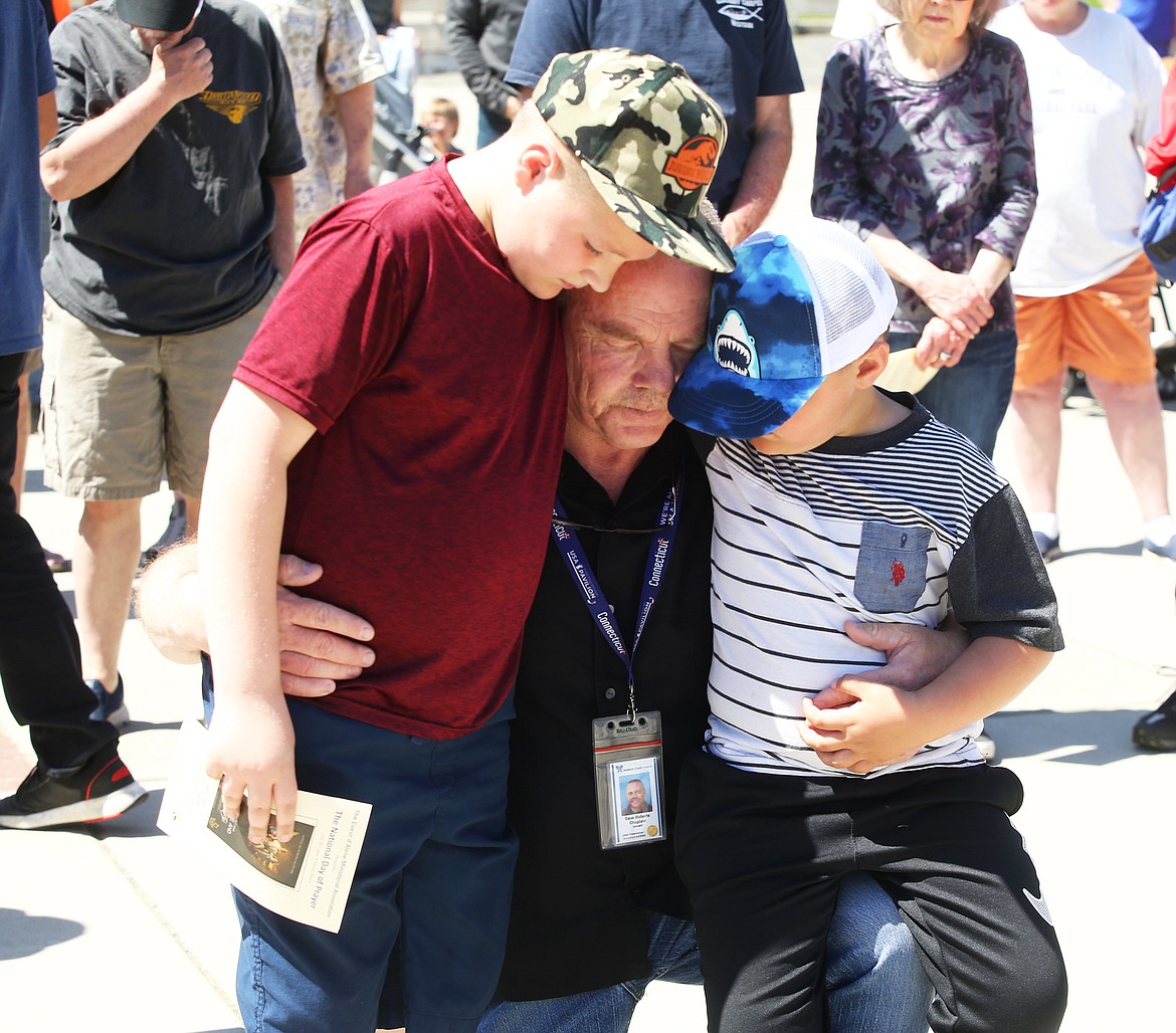 Dave Roberts holds his grandsons Nicolas and Dominic at the National Day of Prayer gathering in Coeur d'Alene on Thursday.