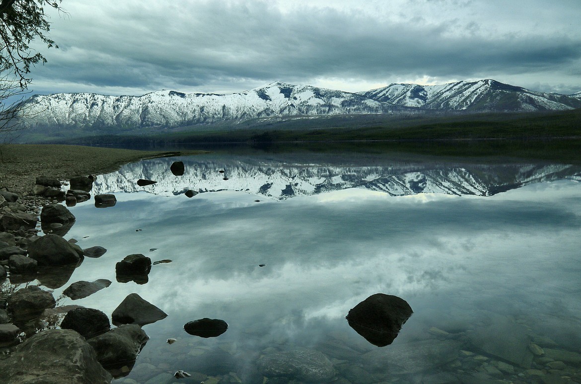 Spring silhouette: A serene Lake McDonald in Glacier National Park reflects the surrounding peaks on April 29. (Patrick Booth/Mystic Creek Studios)