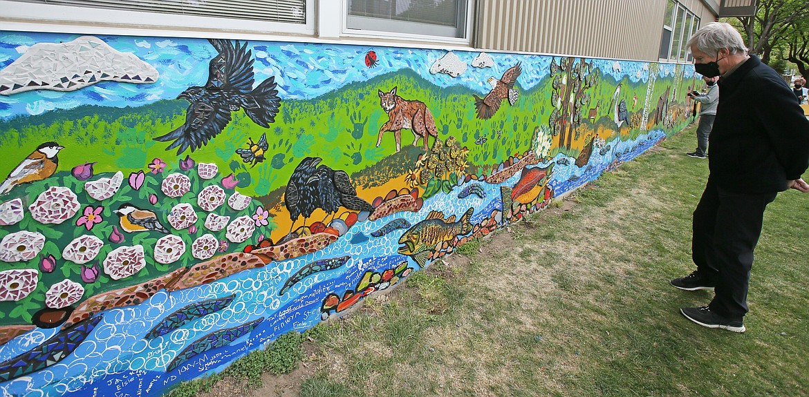 Steve Moss inspects the new mural outside of Sorensen Magnet School while waiting for his granddaughter on Friday. "It's really impressive," Moss said.