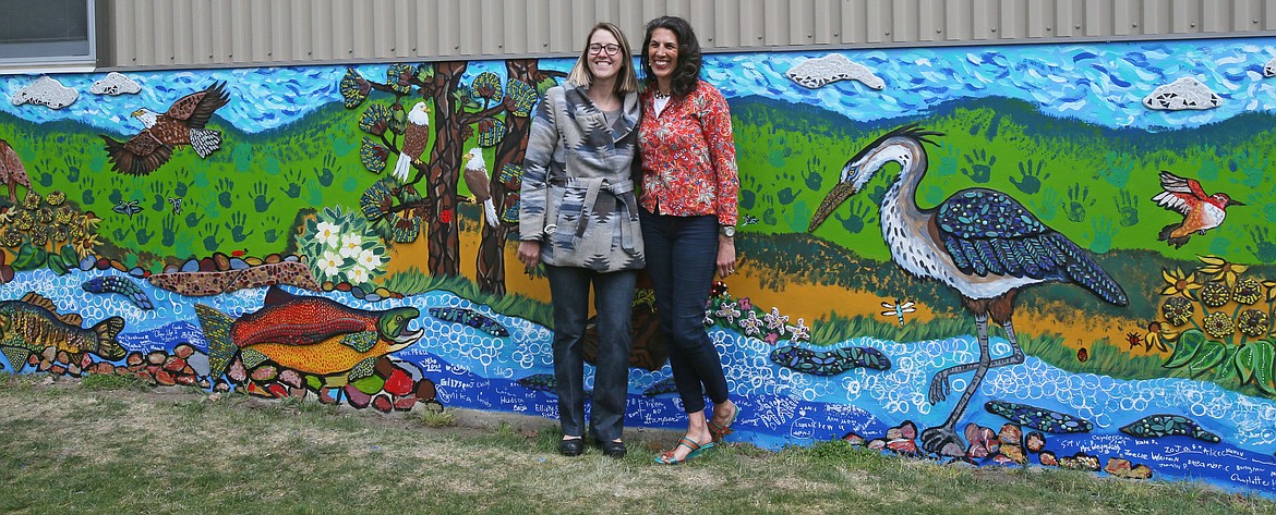 Sorensen art director Jill McFarlane, left, and Spokane artist Melissa Cole, who served as the school's artist-in-residence this spring, smile for the camera Friday in front of the newly completed mural that students worked on under Cole's guidance.