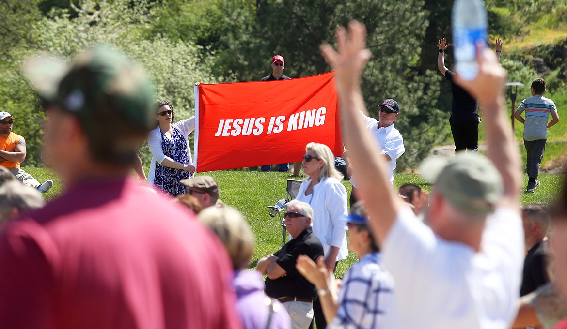 People hold a banner at the National Day of Prayer gathering in Coeur d'Alene on Thursday.