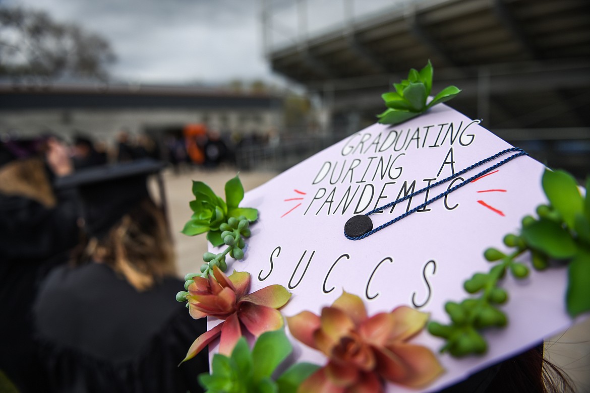 Danielle Rae Rosenbaum adorns a message on her mortarboard with succulents as graduates wait to take their seats before the Flathead Valley Community College commencement ceremony at Legends Stadium on Friday. (Casey Kreider/Daily Inter Lake)