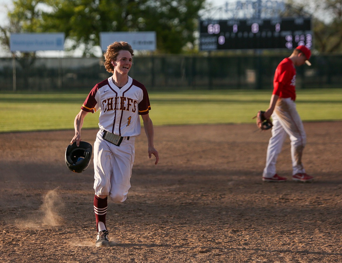 Blaine Macdonald rushes to celebrate with his teammates after hitting in the winning run in the 11th inning against Eastmont High School on Friday afternoon at Larsen Playfield in Moses Lake.