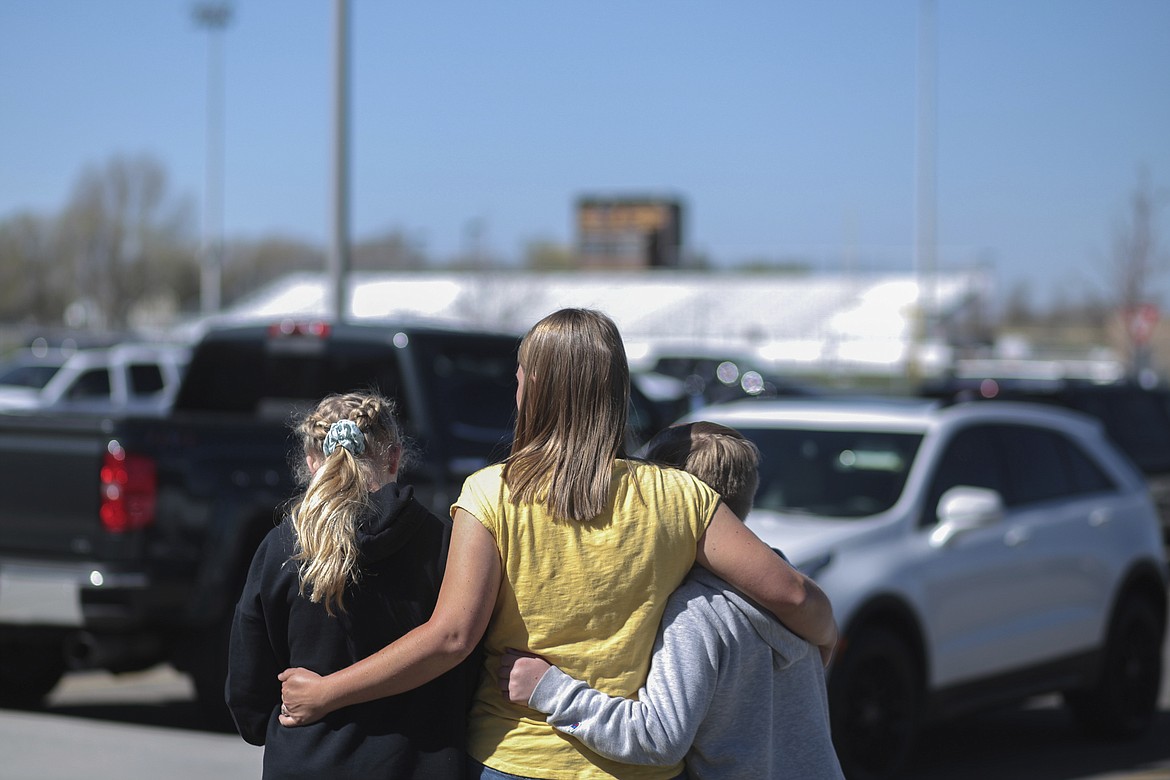 People embrace outside after a shooting at Rigby Middle School in Rigby, Idaho on Thursday, May 6, 2021. Authorities say a shooting at the eastern Idaho middle school has injured two students and a custodian, and a female student has been taken into custody. (John Roark /The Idaho Post-Register via AP)